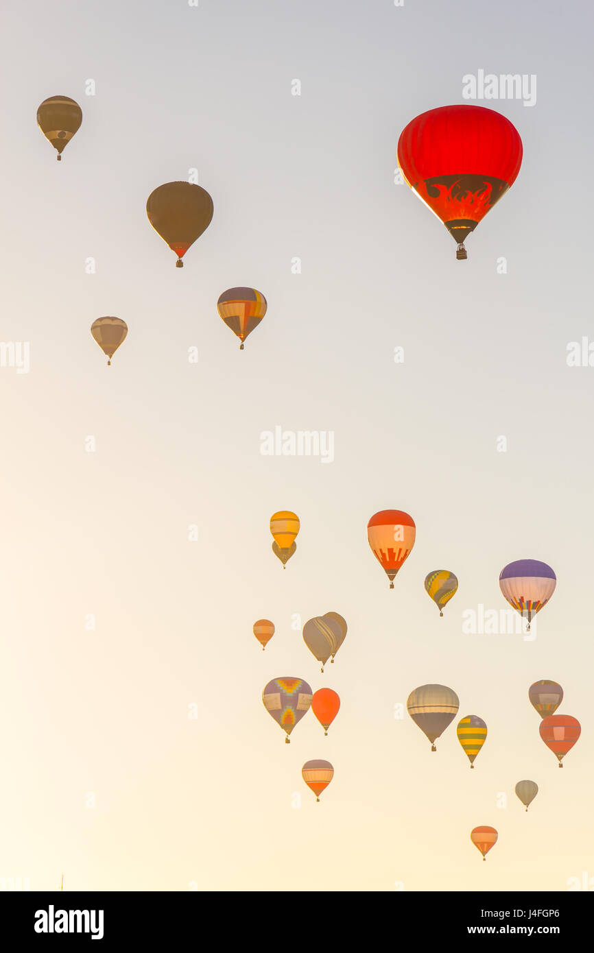 Group of Colored hot air balloons flying in a blue sky in the sunset ...