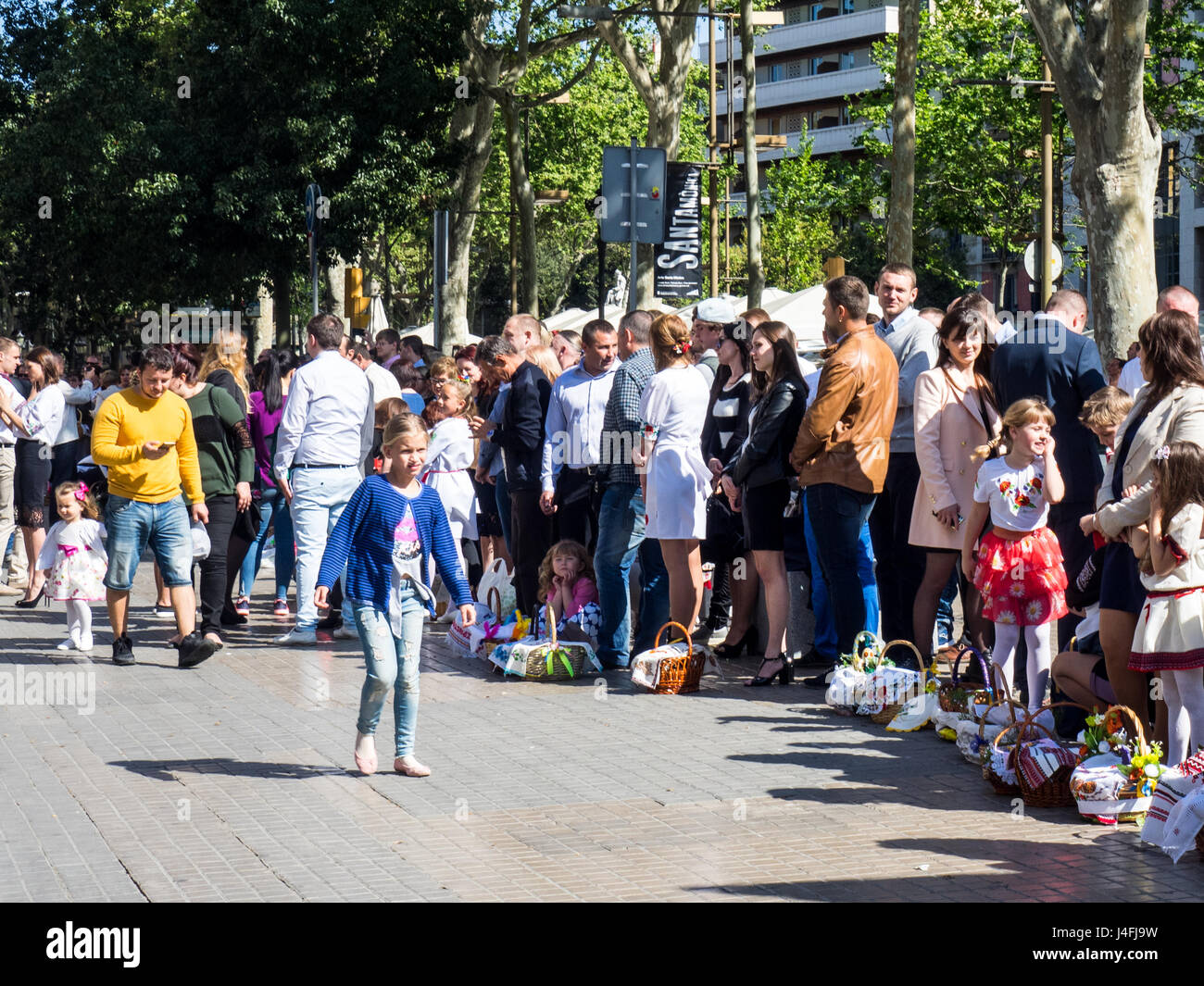 A young girl walking in front of a crowd of families celebrating Russian Orthodox Easter. Stock Photo