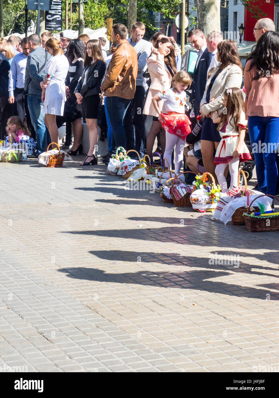 Families standing together with baskets of eggs, sedmista and cakes celebrating Russian Orthodox Easter. Stock Photo