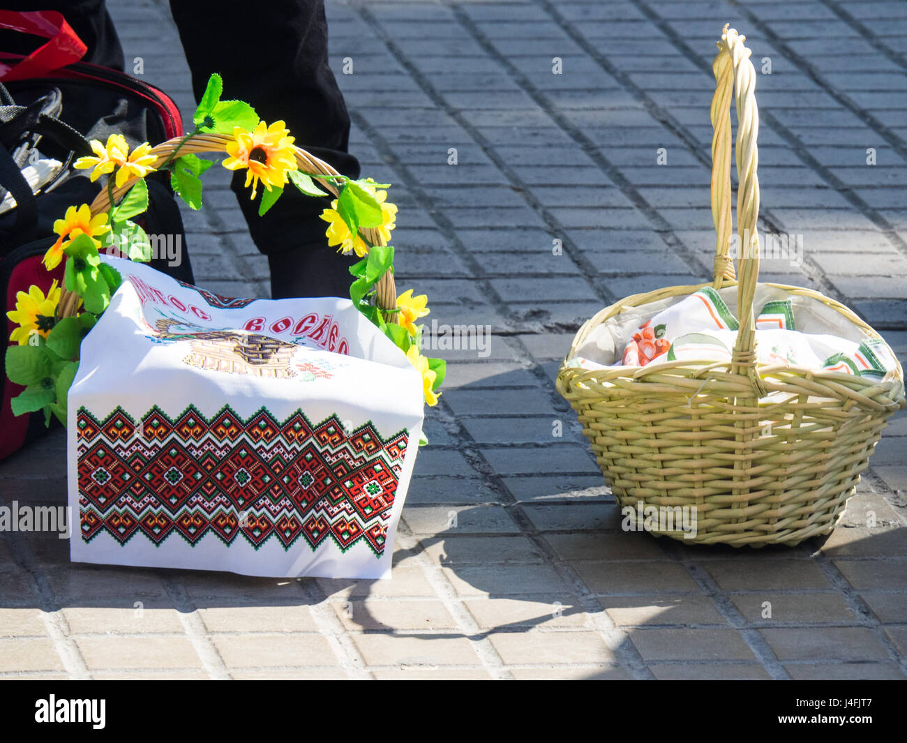 Cane baskets covered with embroidered napkins with Easter offerings of eggs and cakes to celebrate the Russian Orthodox Easter. Stock Photo