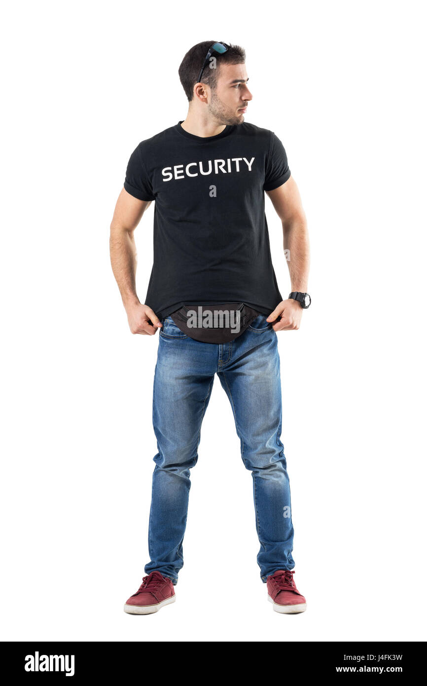 Cautious undercover police officer adjusting shirt looking away alerted. Full body length portrait isolated on white studio background. Stock Photo
