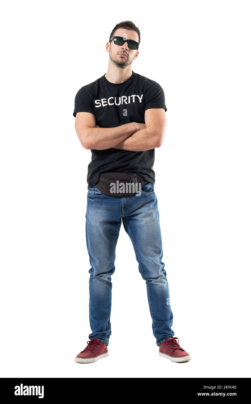 Macho bouncer or undercover cop in plain clothes looking at camera with crossed arms. Full body length portrait isolated on white studio background. Stock Photo