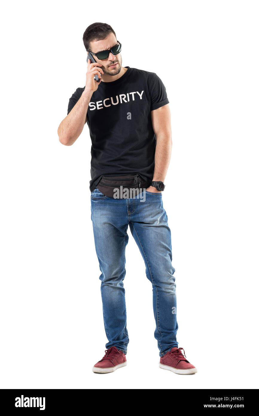 Upset angry undercover plainclothes policeman on the phone looking away. Full body length portrait isolated on white studio background. Stock Photo