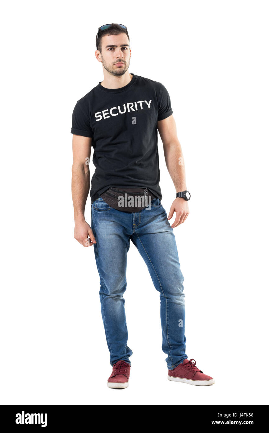 Serious confident young plainclothes officer with fanny pack looking at camera. Full body length portrait isolated on white studio background. Stock Photo
