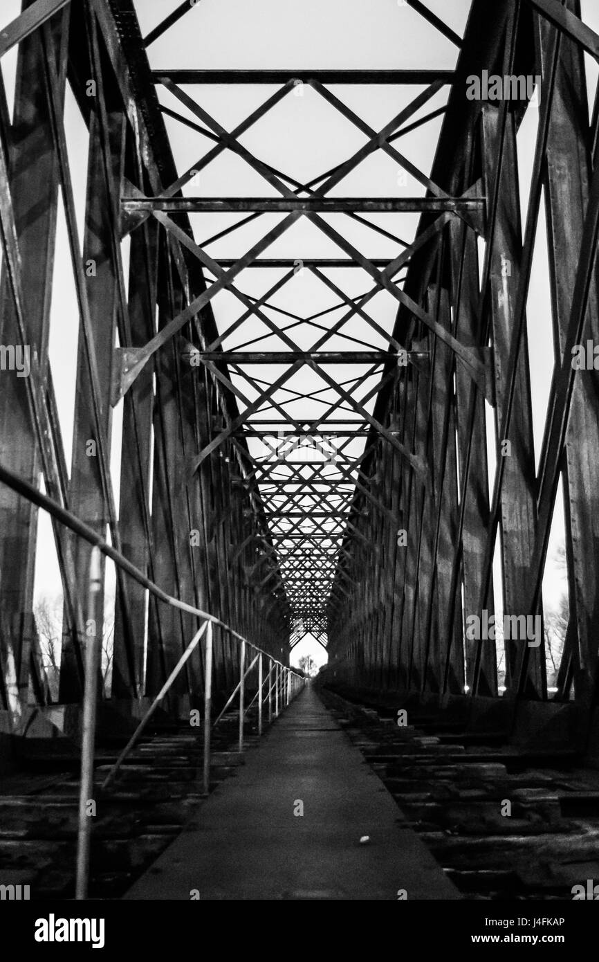 Black and white old industrial railway railroad iron bridge center perspective in night Stock Photo