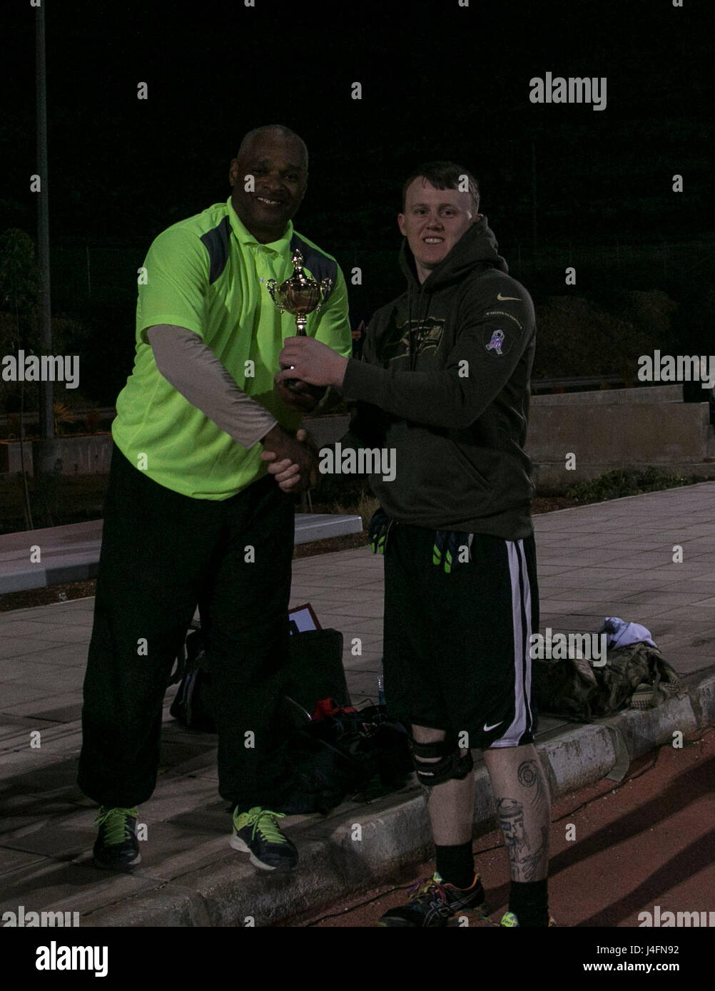 Sgt. Bradley White, of Headquarters and Headquarters Battery, 18th Field Artillery Brigade, receives the Offensive MVP trophy for the flag football league. White played on the unit’s flag football team during his deployment in Southwest Asia. Stock Photo