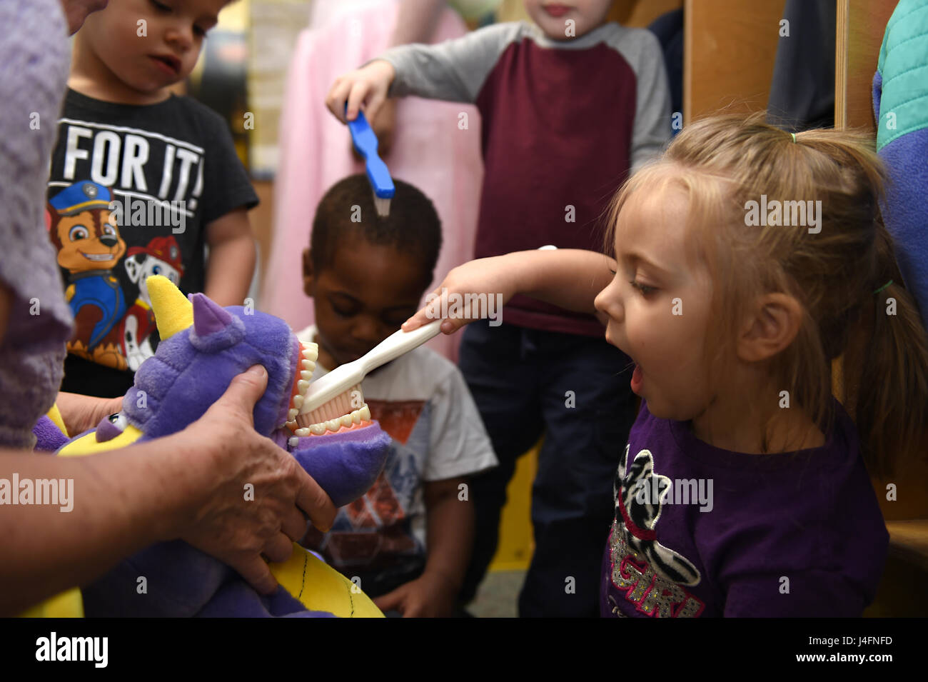 Children at the McChord Child Development Center brush the teeth of a