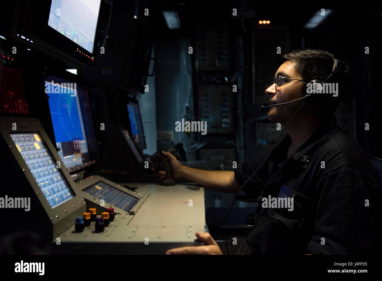 160701-N-OR652-031MEDITERRANEAN SEA (July 1, 2016) – Fire Controlman 3rd Class Tristan Tamez, assigned the guided-missile cruiser USS San Jacinto (CG 56), stands watch in the ship’s combat information center. Jacinto is deployed in support of Operation Inherent Resolve, maritime security operations and theater security operation efforts in the U.S. 6th Fleet area of operations. (U.S. Navy photo by Mass Communication Specialist 3rd Class J. Alexander Delgado/Released) Stock Photo