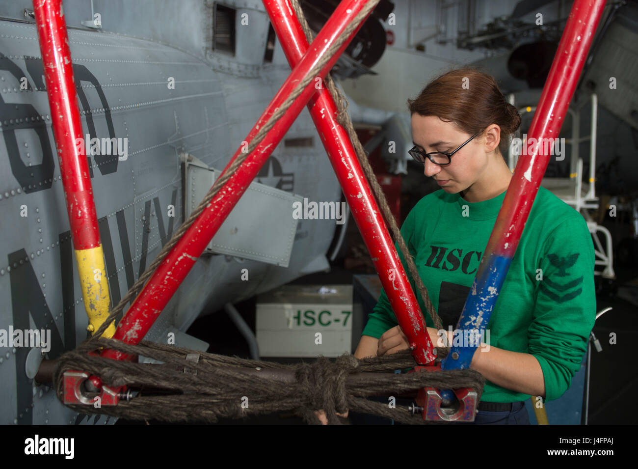 160704-N-WC455-056  MEDITERRANEAN SEA (July 4, 2016) – Aviation Structural Mechanic 2nd Class Jennifer Cartwright clamps the rotor blades of an MH-60S Sea Hawk assigned to the Dusty Dogs of Helicopter Sea Combat Squadron (HSC) 7 in the hangar bay of the aircraft carrier USS Dwight D. Eisenhower (CVN 69) (Ike). Ike is deployed in support of Operation Inherent Resolve, maritime security operations and theater security operation efforts in the U.S. 6th Fleet area of operations. (U.S. Navy photo by Mass Communication Specialist Seaman Apprentice Joshua Murray/Released) Stock Photo