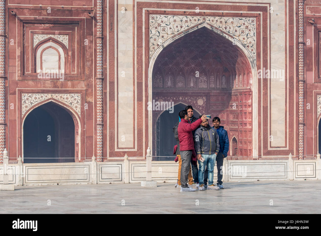 Tourists taking photos just outside of the main tomb entrance of the Taj Mahal, located in Agra, India. Stock Photo