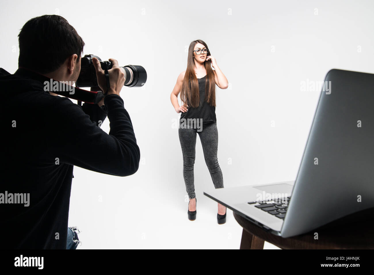 Photographer Using Model Photographer working with model in equipped studio Stock Photo - Alamy