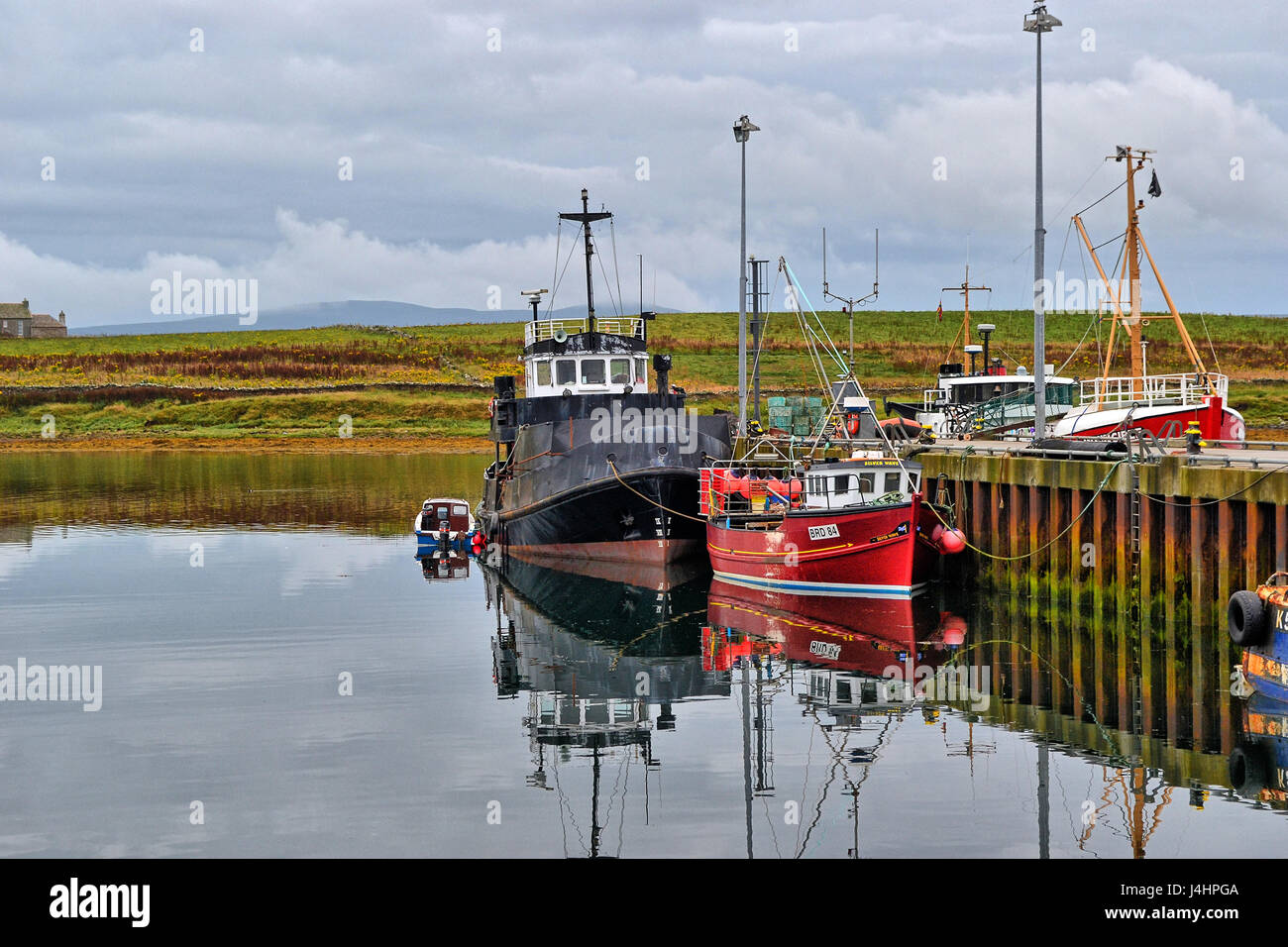 Fishing boats reflections at Stromness Harbour, Orkney, Scotland, UK Stock Photo
