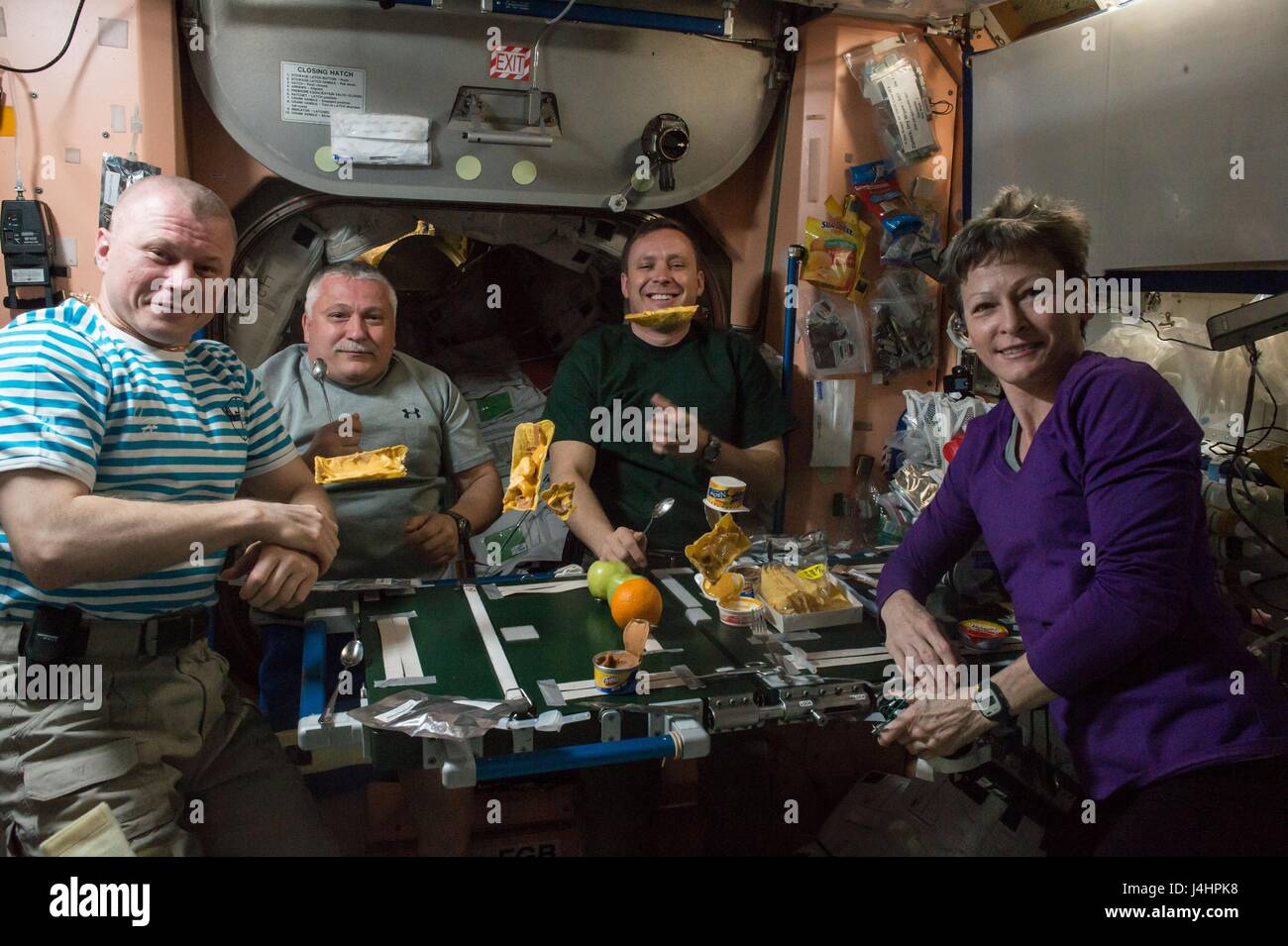 NASA International Space Station Expedition 51 prime crew members (L-R) Russian cosmonauts Oleg Novitskiy and Fyodor Yurchikhin of Roscosmos, and American astronauts Jack Fischer and Peggy Whitson share a meal inside the ISS Unity module April 23, 2017 in Earth orbit.     (photo by NASA via Planetpix) Stock Photo