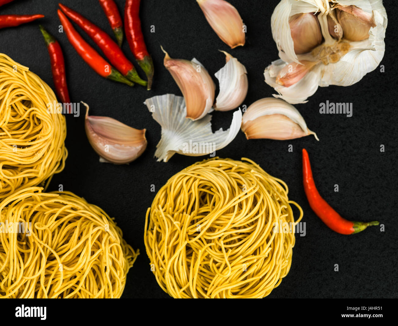 Uncooked Chinese Style Fine Egg Noodles Nests With Chilli and Garlic on