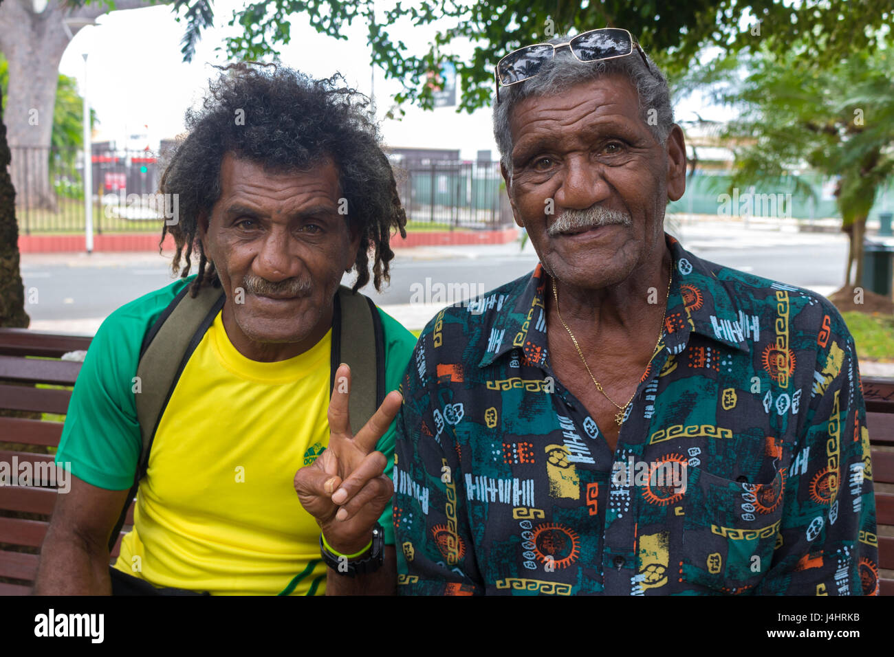 Noumea, New Caledonia - February 26th, 2017: Portrait of two new caledonian senior men looking at camera, sitting at Place de la Marne, Noumea. Stock Photo