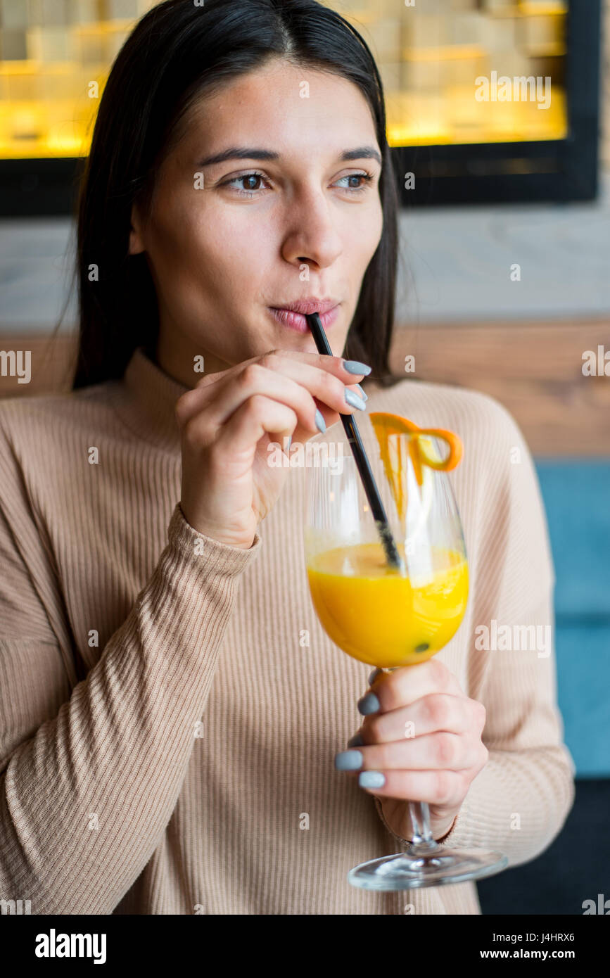 Young woman drinking orange juice in cafe Stock Photo Alamy