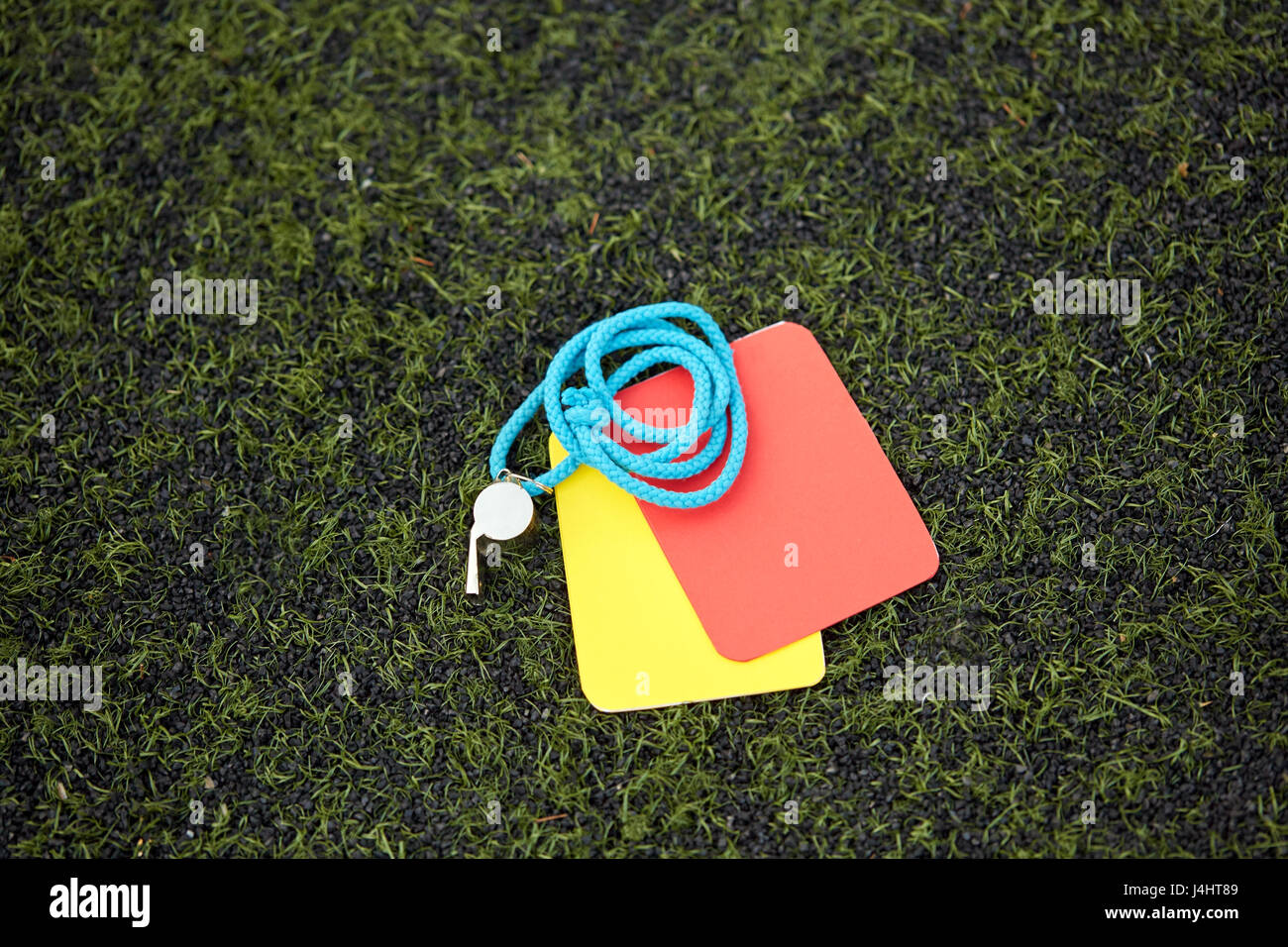 referee whistle and caution cards on soccer field Stock Photo