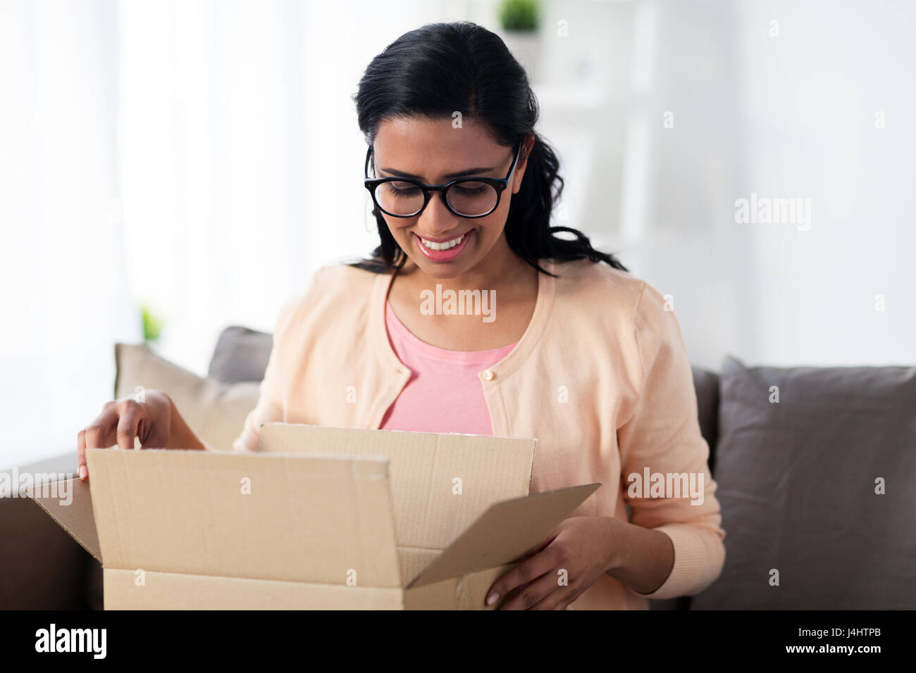 happy young indian woman with parcel box at home Stock Photo