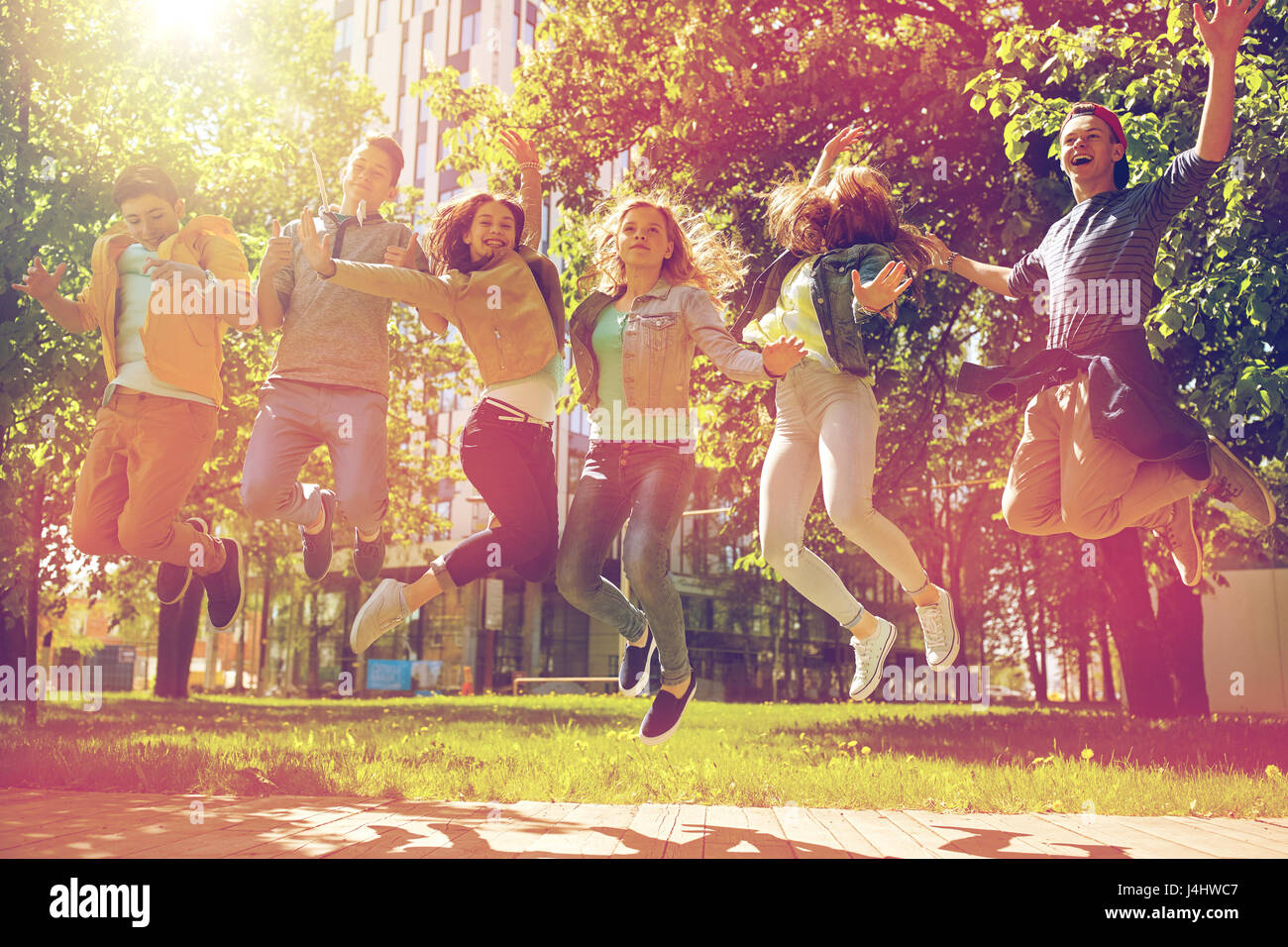 happy teenage students or friends jumping outdoors Stock Photo - Alamy