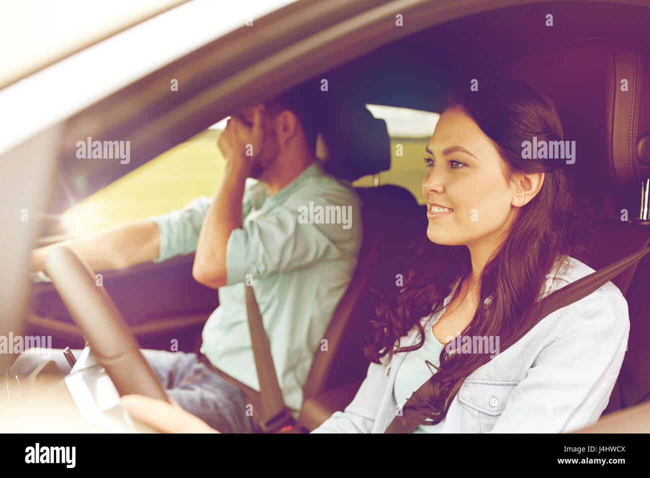 woman driving car and man covering face with palm Stock Photo