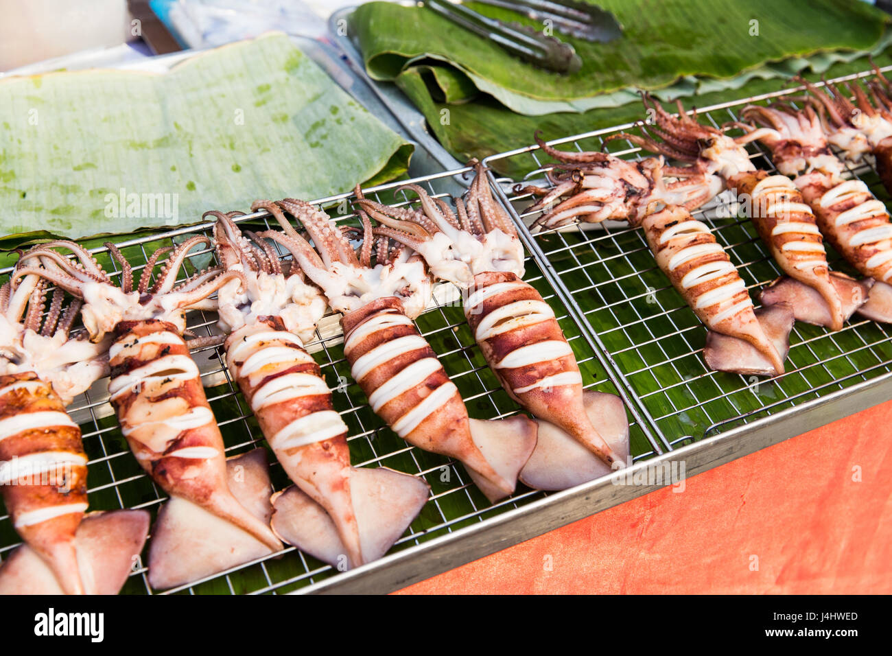 squids on grill at street market Stock Photo