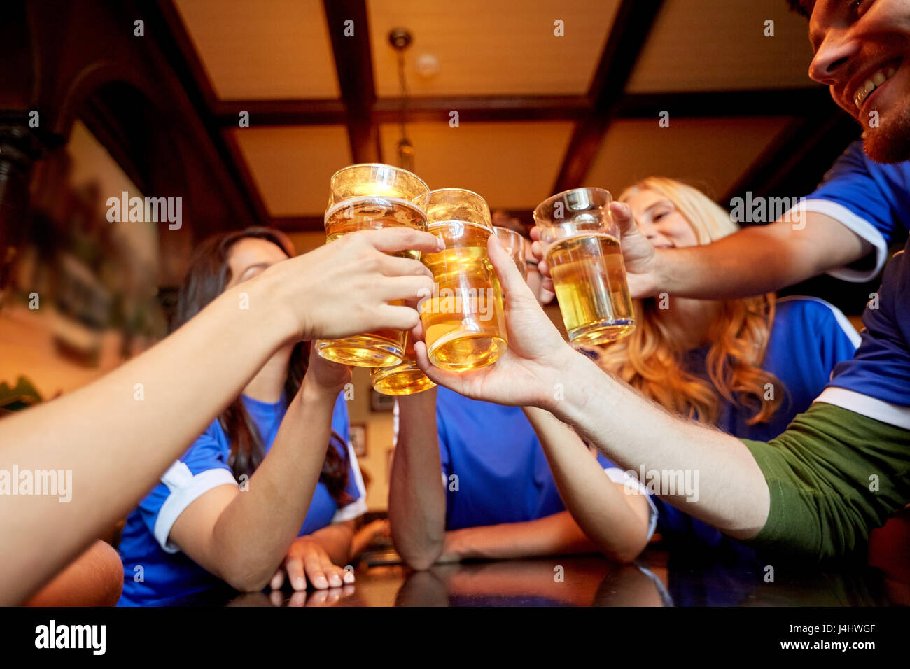 football fans clinking beer glasses at sport bar Stock Photo Alamy