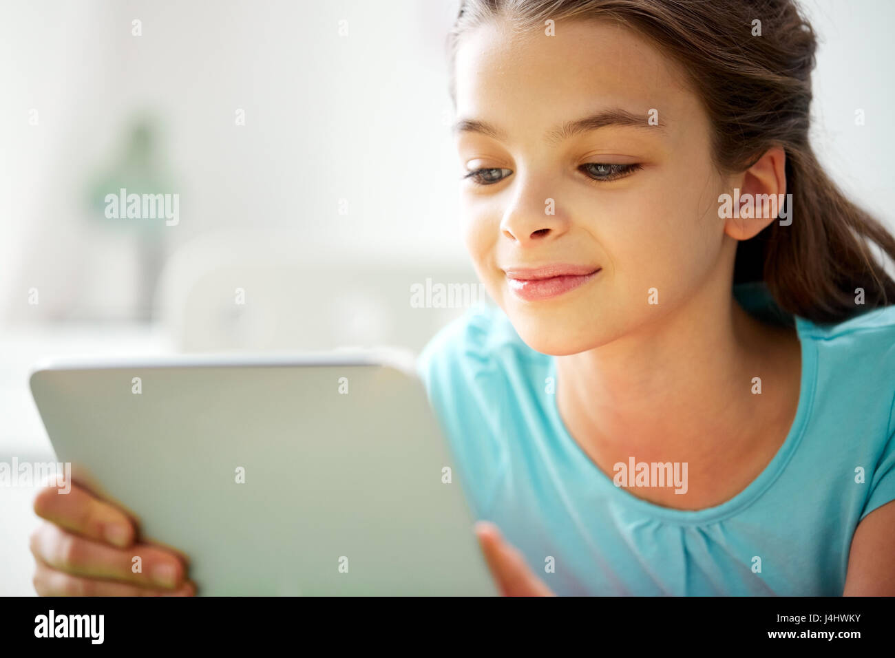 close up of smiling girl with tablet pc at home Stock Photo