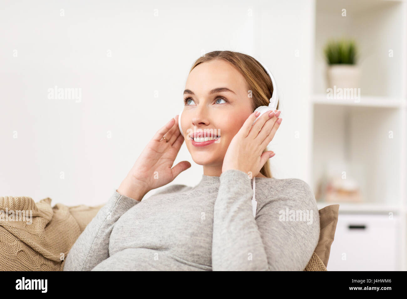 pregnant woman with headphones listening to music Stock Photo - Alamy