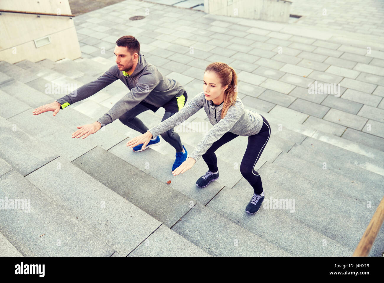 couple doing squats on city street stairs Stock Photo Alamy