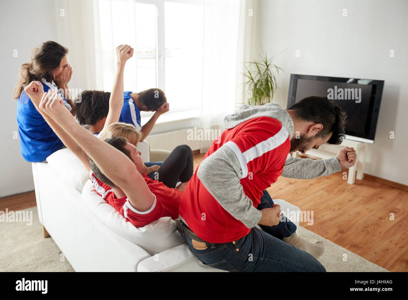 friends or football fans watching tv at home Stock Photo