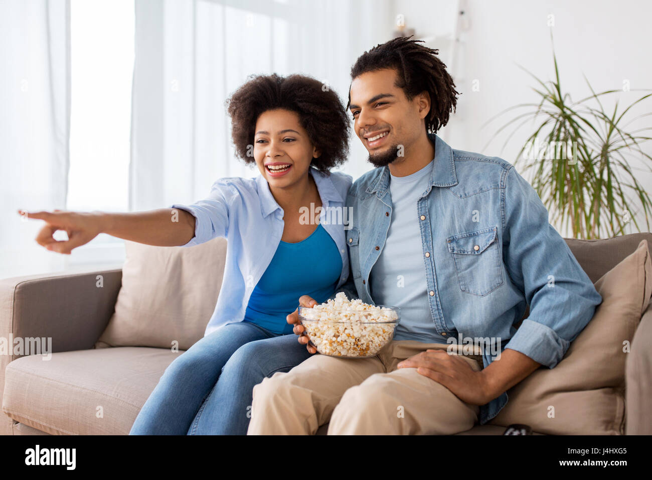 smiling couple with popcorn watching tv at home Stock Photo - Alamy