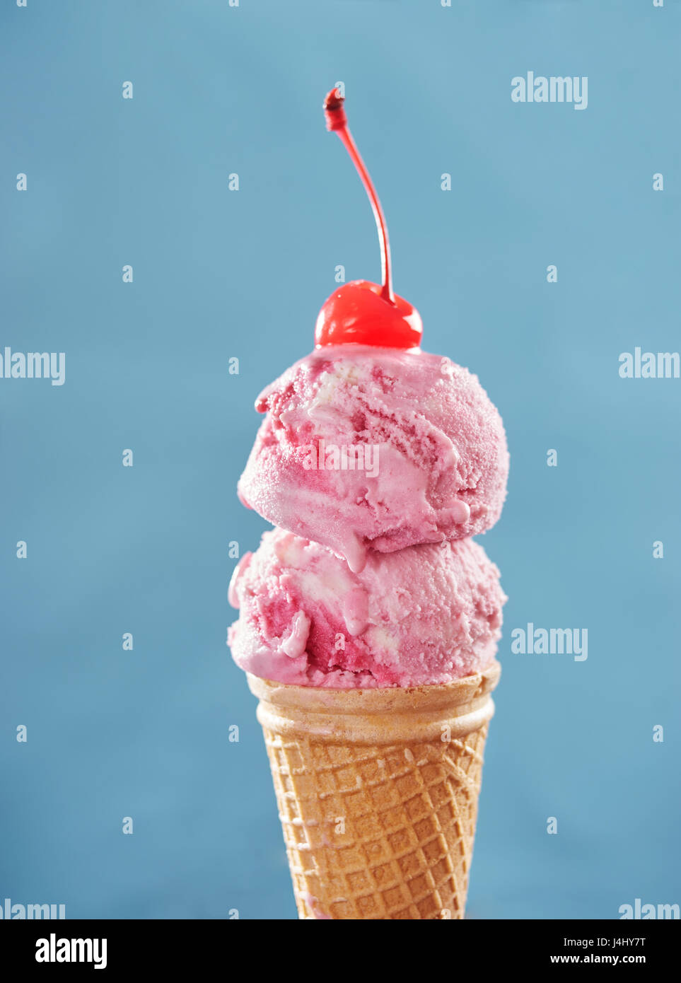 Pink ice cream cone with cherry Stock Photo