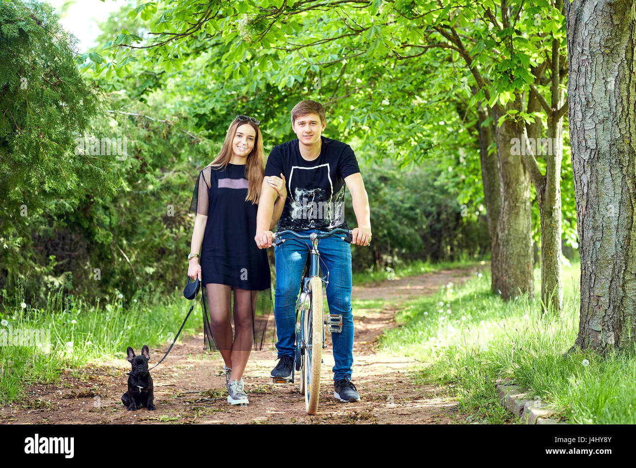 Portrait of a loving couple on bicycle with  dog in the park Stock Photo