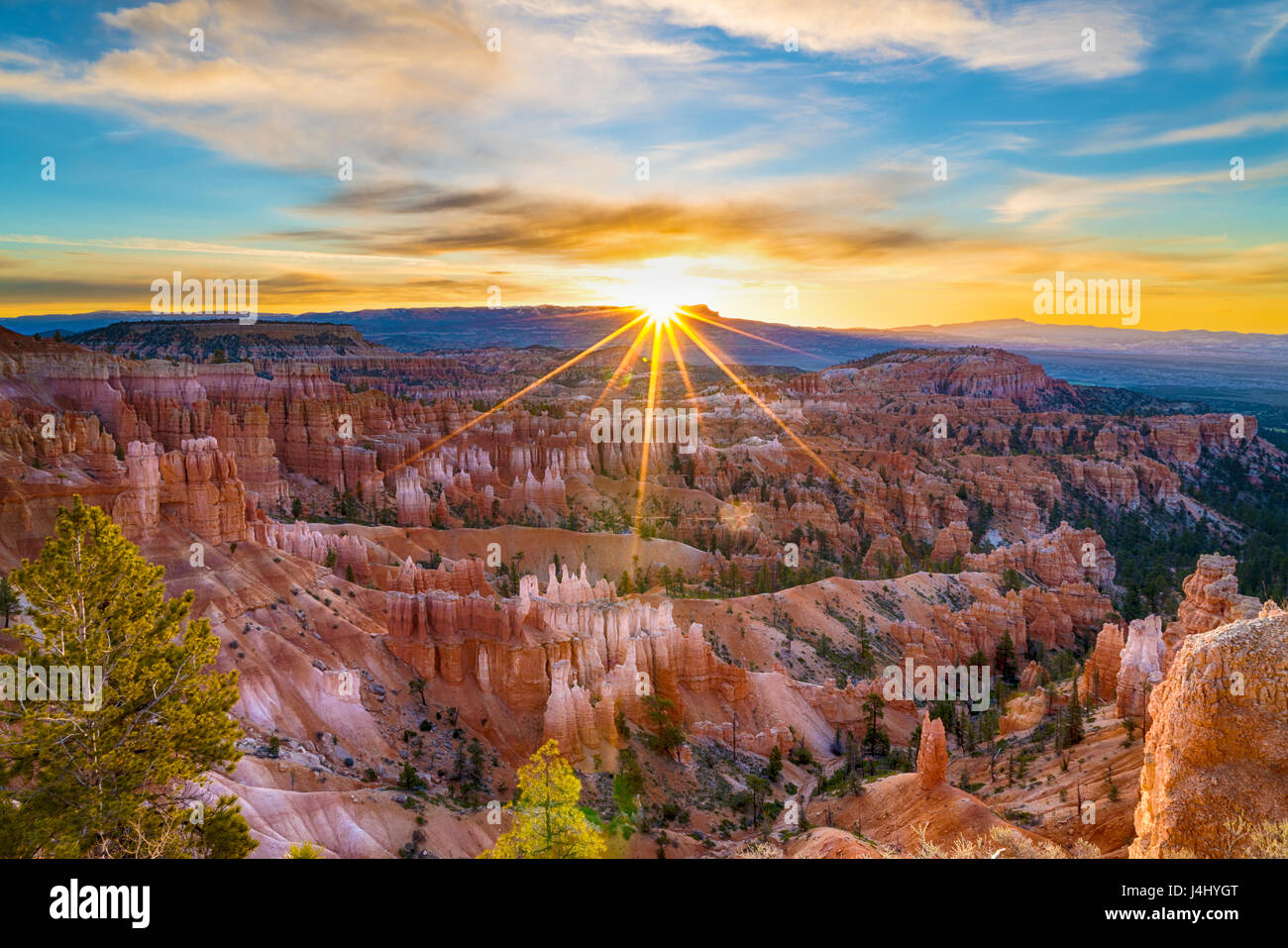 Sun rising above the horizon with sun rays at Bryce Canyon national ...