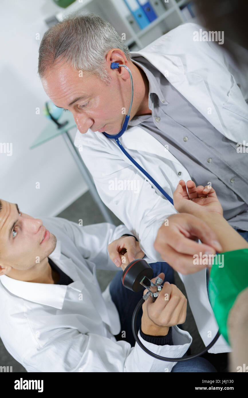 Student nurse learning how to take blood pressure reading Stock Photo