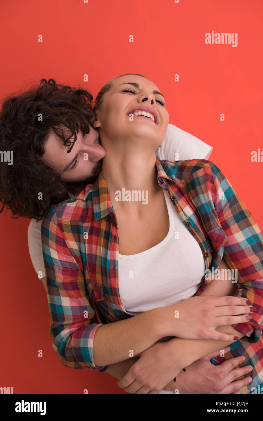 Portrait of a happy young smiling couple in love over color background ...
