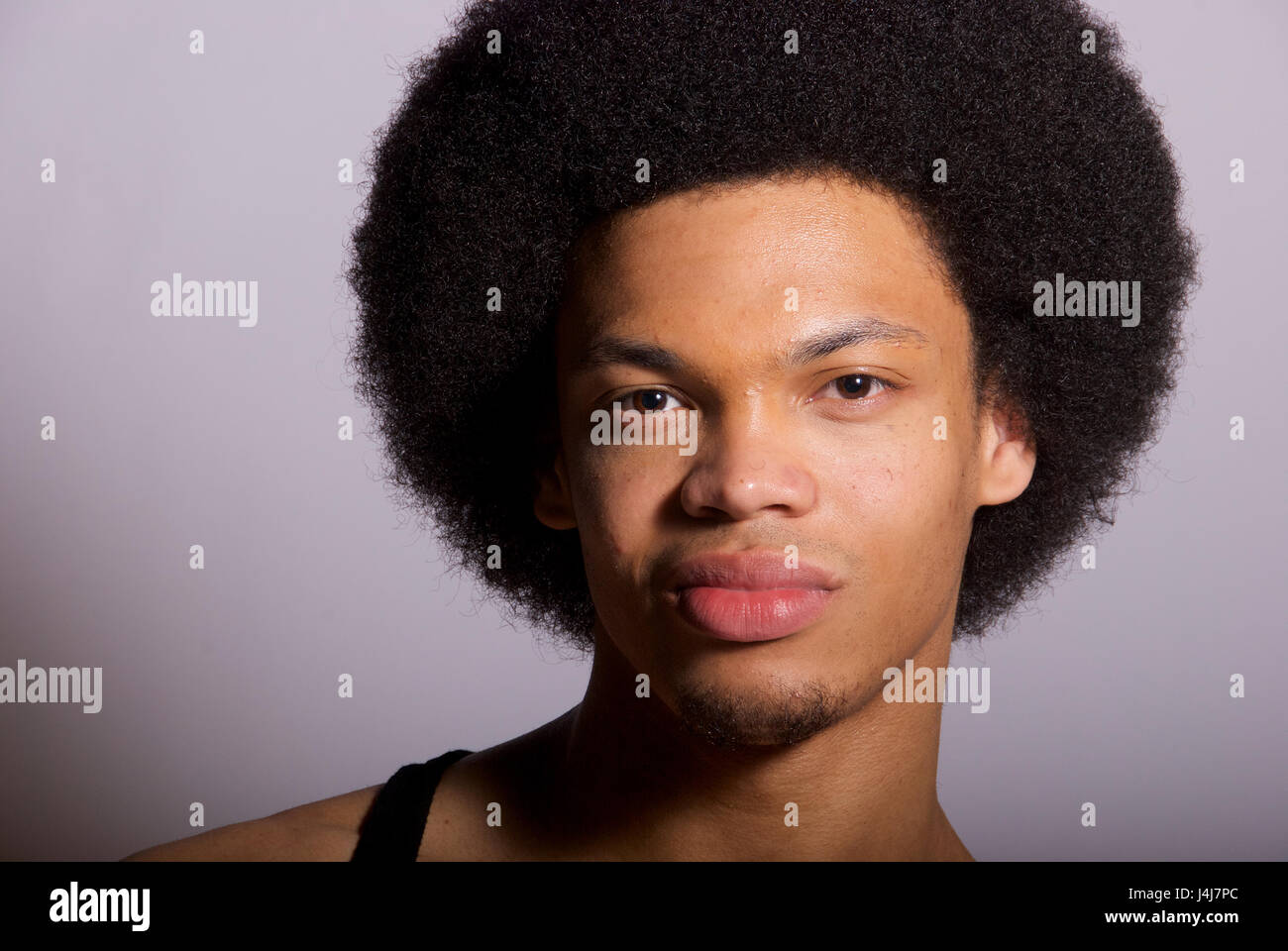 Young black man with afro hairstyle in a studio - head shot Stock Photo