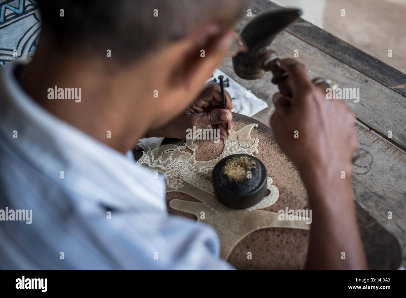 A local craftsman making  leather puppets (wayang kulit) in Yogyakarta, Java, Indonesia. Stock Photo
