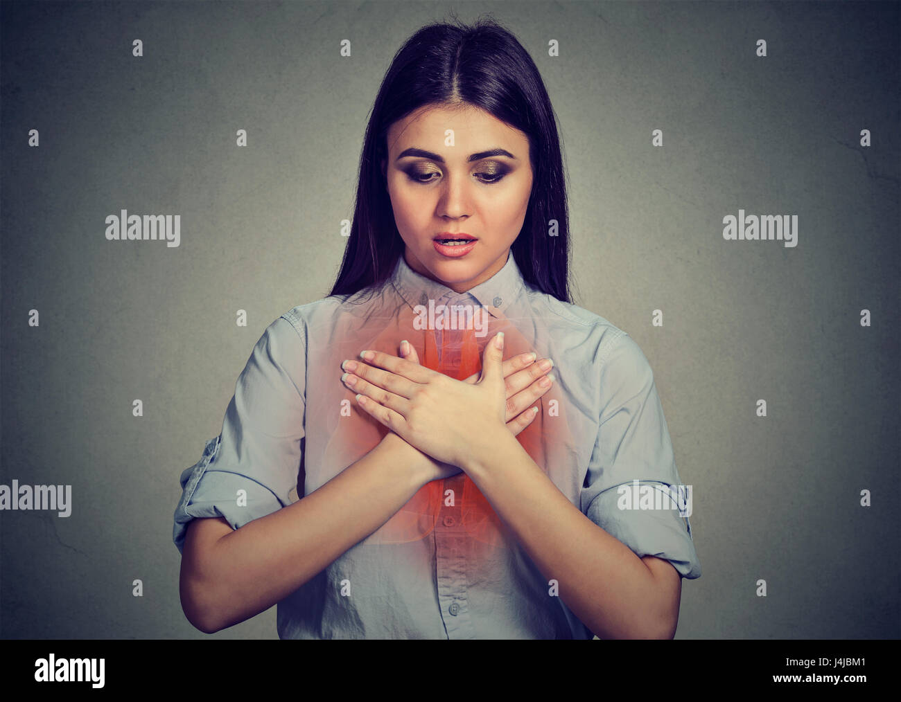 Young woman with asthma attack or respiratory problem isolated on gray background Stock Photo