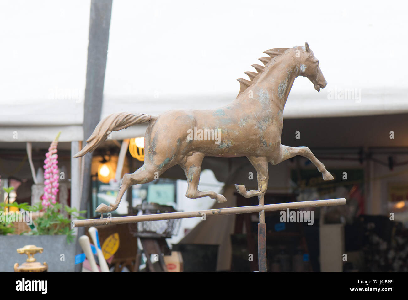 Running horse weathervane enlivens flea market wares. Stock Photo