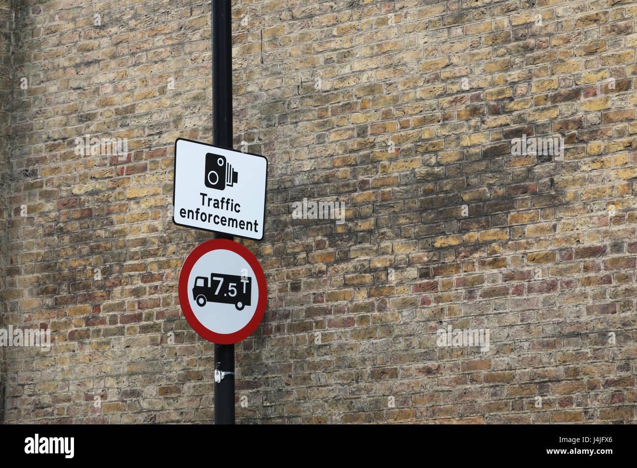 Traffic enforcement and weight limit sign against brick wall Stock Photo