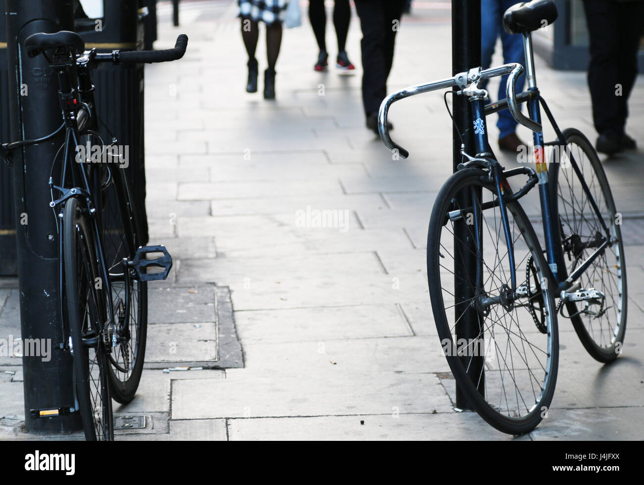 Two bicycles chained to sign posts Stock Photo