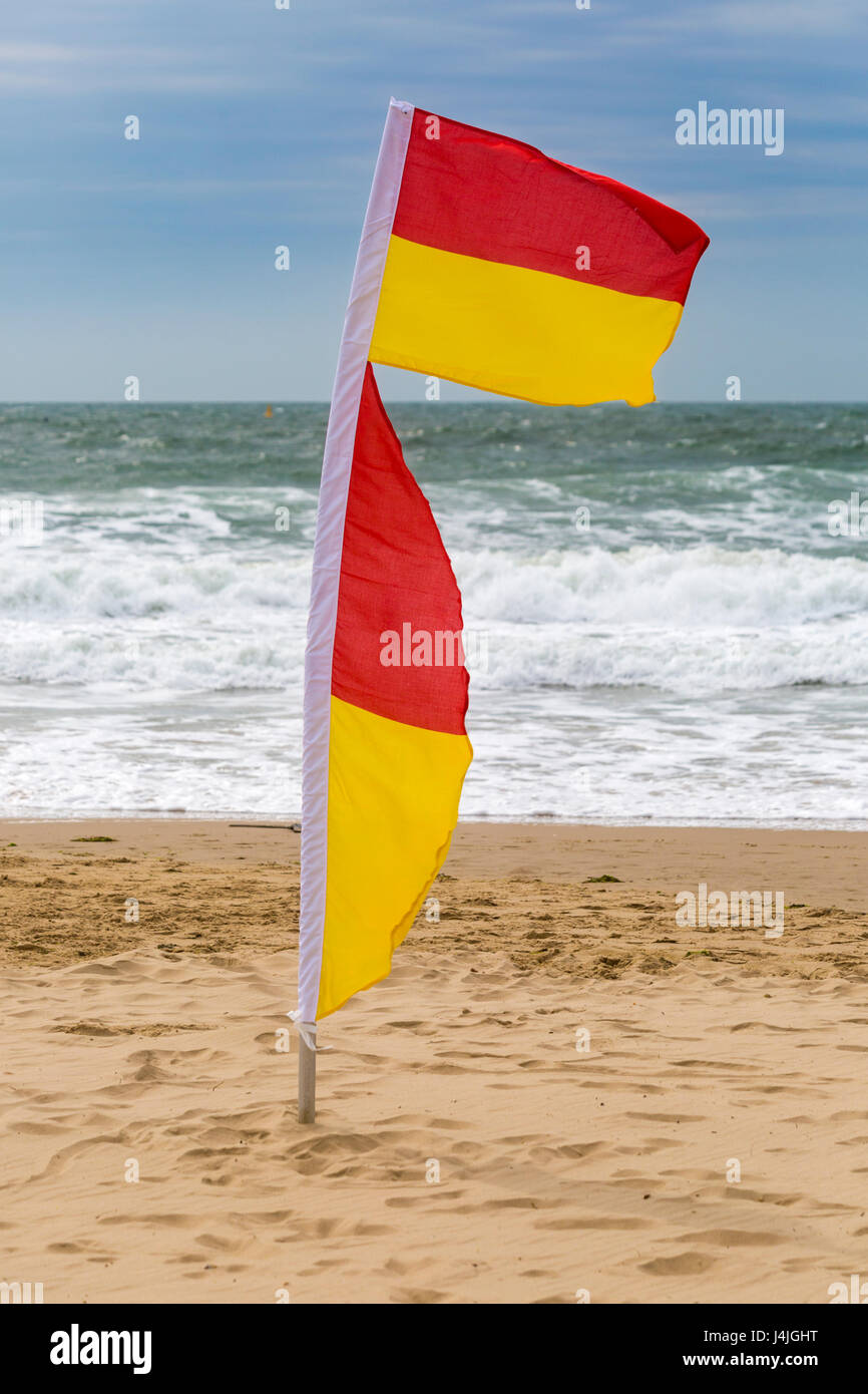 red and yellow flags indicating safe area to swim at the seaside on  Bournemouth beach in April Stock Photo - Alamy