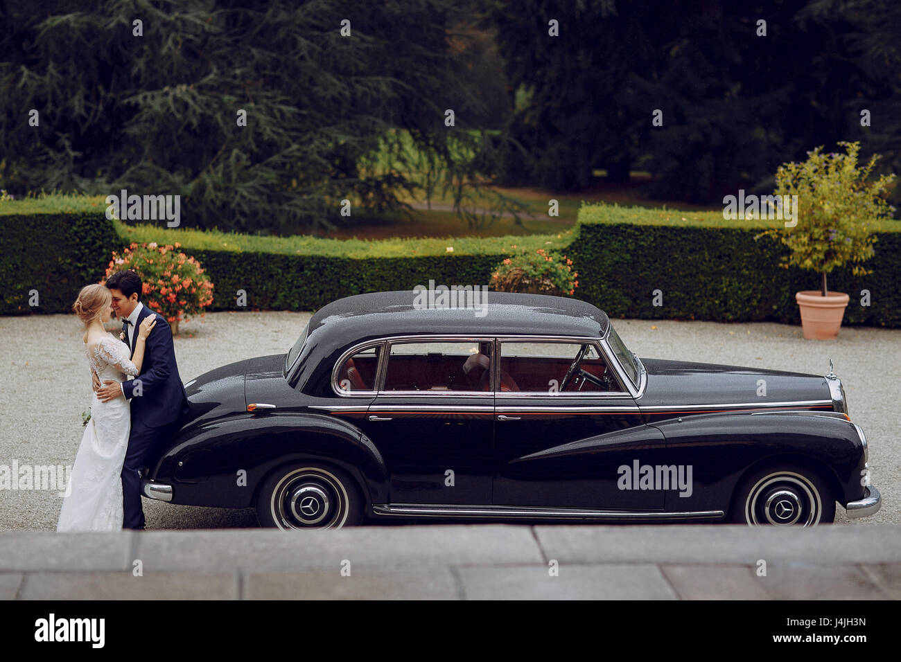 bride and groom standing in the yard near the car Stock Photo - Alamy