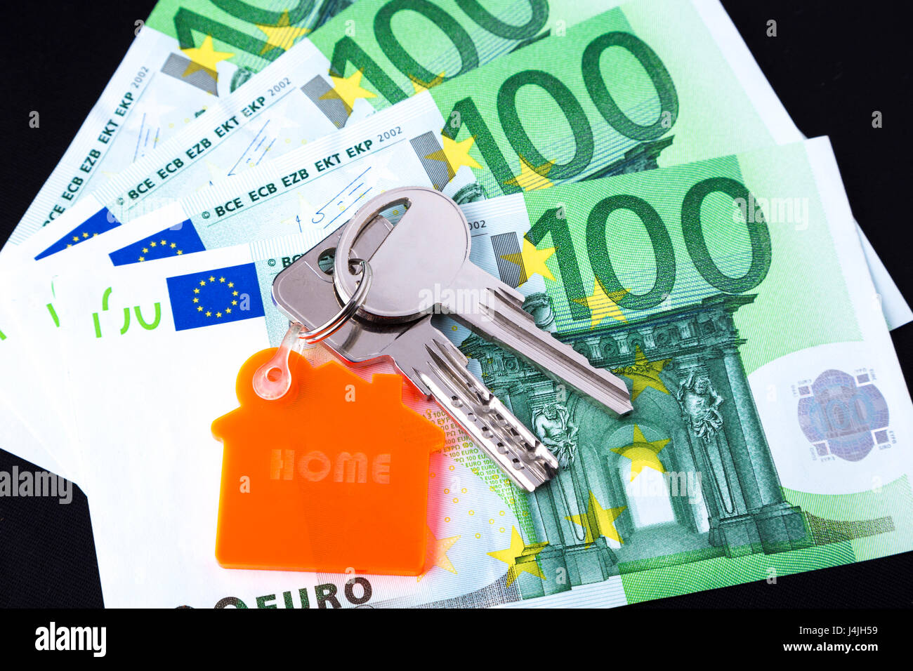 House keys with a keychain on top on 100 Euro notes studio shot Stock Photo