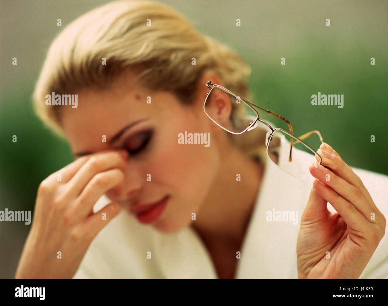 Woman, young, blond, glasses, hold, gesture, cephalalgias manager, Schmezen, head, rewrite, fatigue, overfatigue, depletion, tiredly, outside, blur Stock Photo