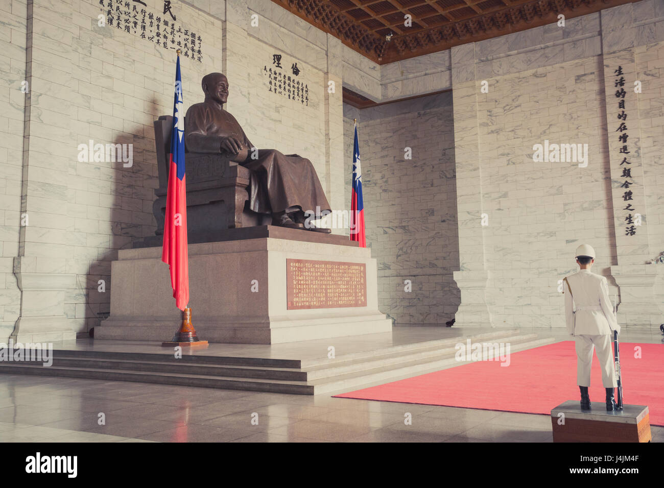 Seated bronze statue of Chiang Kai-Shek with a Honor Guard in white uniform in position, at the Chiang Kai-Shek Memorial Hall in Taipei Stock Photo