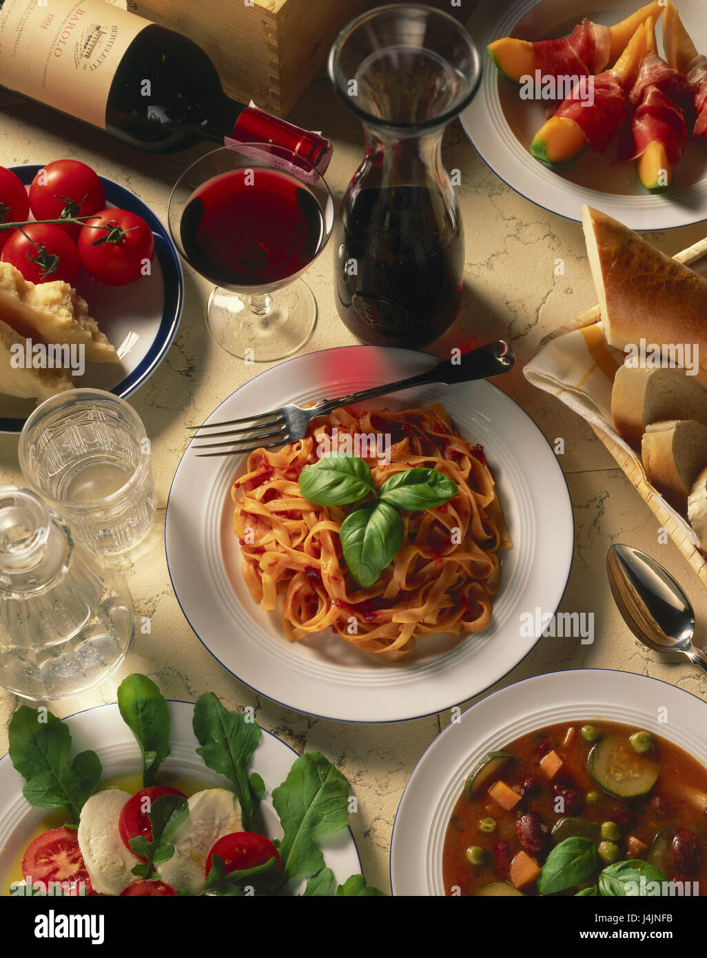 Dishes, drinks, in Italian, specialities still life, object photography, foods, food, hors-d'oeuvre, honeydew melon, melon, bacon, main meal, noodles, pasta dish, tagliatelle Al Pomodoro, Minestrone, vegetable soup, salad, tomatoes, mozzarella, wine, red, wineglass, red wine, alcoholic, alcohol, bread, baguette Stock Photo