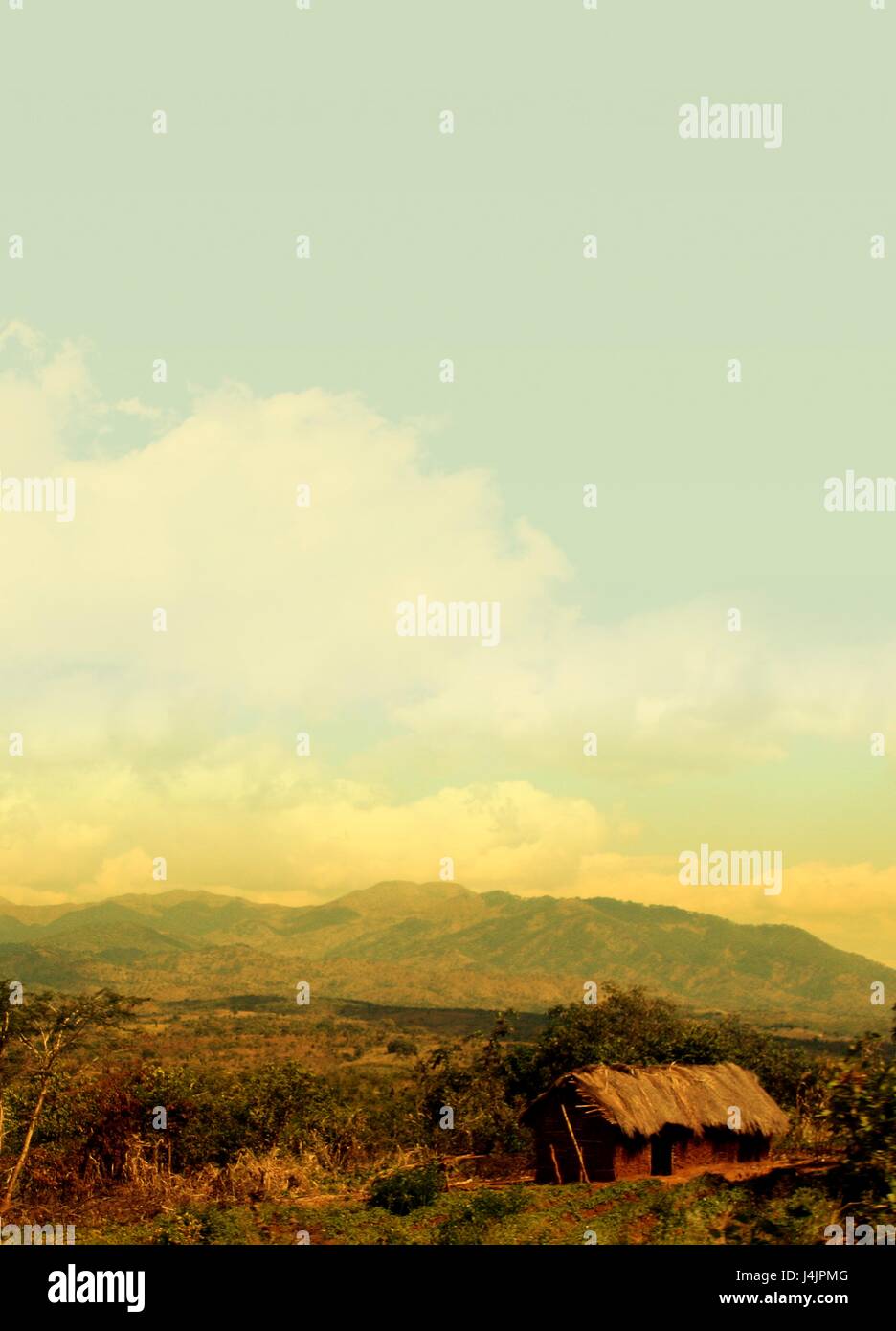 Rural scene with hut and mountains. Photographed in Africa. Stock Photo