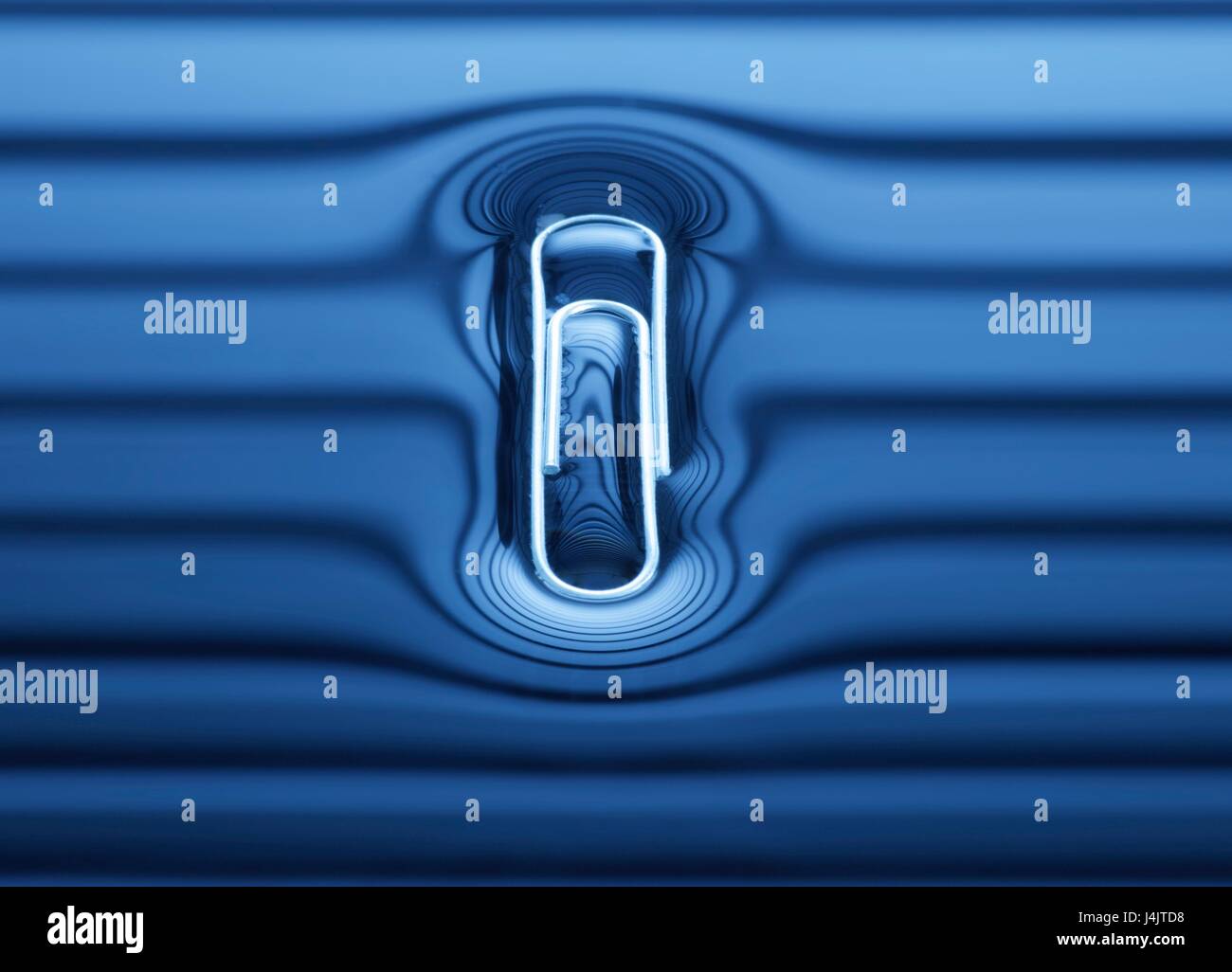 Paperclip floating on the water surface. Stock Photo